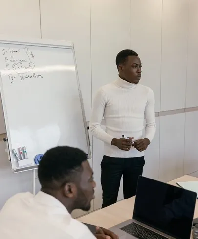 Team members reviewing project notes on a laptop during a confident office discussion